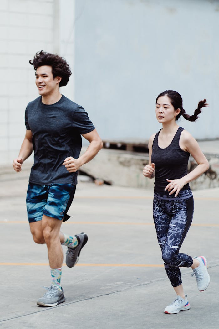 hero-img-02 Asian couple jogging together outdoors, promoting healthy lifestyle and fitness.